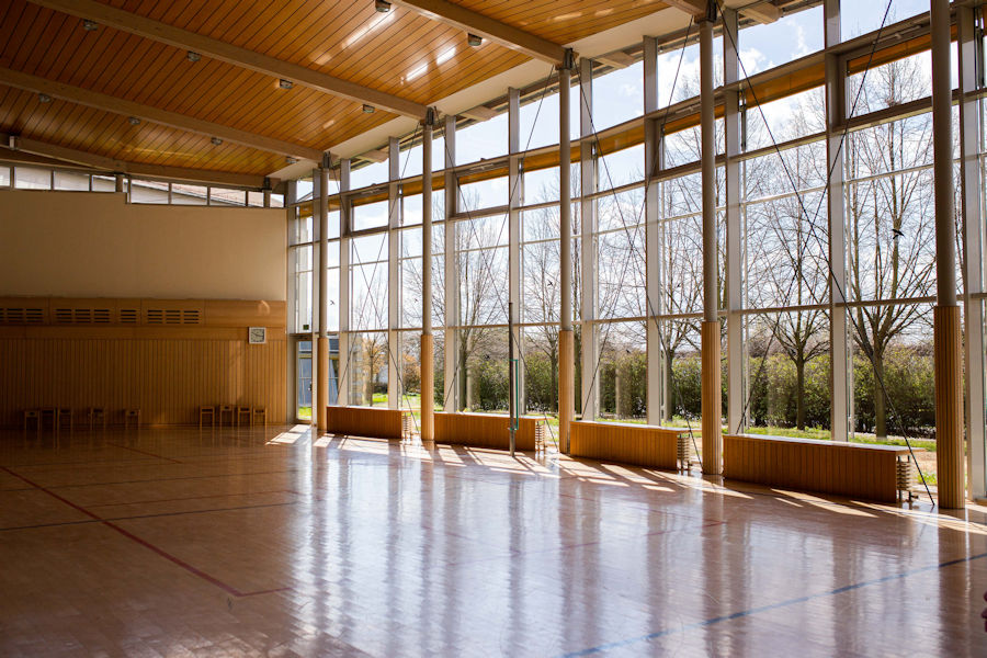 Gymnastikhalle mit Blick durch große Fenster nach Draußen Gymnastikhalle mit Blick durch große Fenster nach Draußen