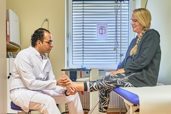 Arzt begutachtet Bein einer Rehabilitandin Arzt begutachtet Bein einer Rehabilitandin